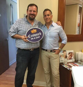 Dr. August de Oliveira with a male patient holding crowned in a day