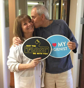 Man kissing the woman while holding signs
