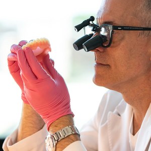Man using microscope to check denture